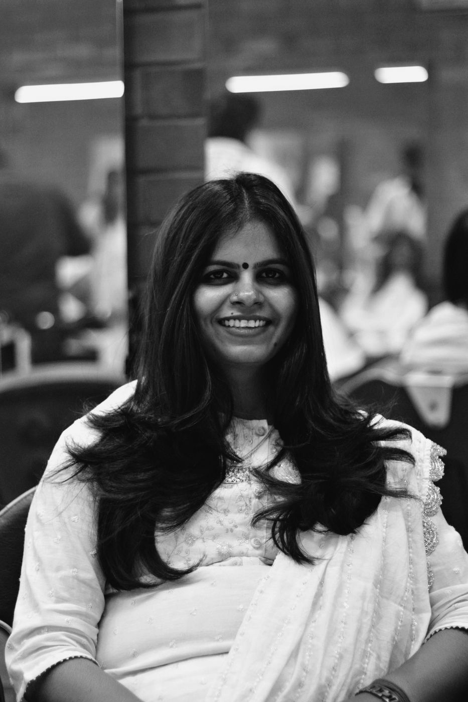 Smiling woman with a long, glossy blow-dry in a salon chair