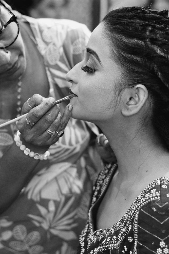 Make-up artist applying lipstick to a bride